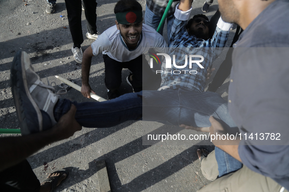 An anti-quota protestor is being taken to the hospital after getting shot during a clash with the pro-government student wing in Dhaka, Bang...