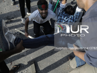 An anti-quota protestor is being taken to the hospital after getting shot during a clash with the pro-government student wing in Dhaka, Bang...