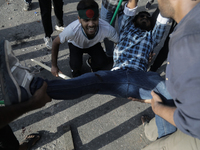 An anti-quota protestor is being taken to the hospital after getting shot during a clash with the pro-government student wing in Dhaka, Bang...