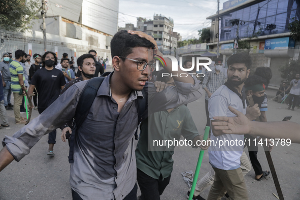 An injured anti-quota protestor is being taken to a hospital during a clash with the pro-government student wing in Dhaka, Bangladesh, on Ju...