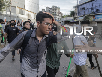 An injured anti-quota protestor is being taken to a hospital during a clash with the pro-government student wing in Dhaka, Bangladesh, on Ju...