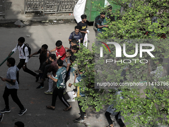 An injured anti-quota protestor is being taken to a hospital during a clash with the pro-government student wing in Dhaka, Bangladesh, on Ju...