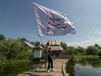 A Kashmiri Shia Muslim boy is waving a flag during a procession in the interiors of Dal Lake in Srinagar, Indian Administered Kashmir, on Ju...