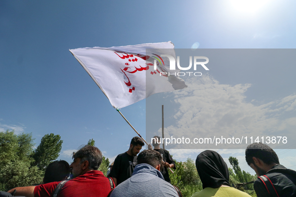 A Kashmiri Shia Muslim man is waving a flag during a procession in the interiors of Dal Lake in Srinagar, Indian Administered Kashmir, on Ju...