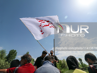 A Kashmiri Shia Muslim man is waving a flag during a procession in the interiors of Dal Lake in Srinagar, Indian Administered Kashmir, on Ju...