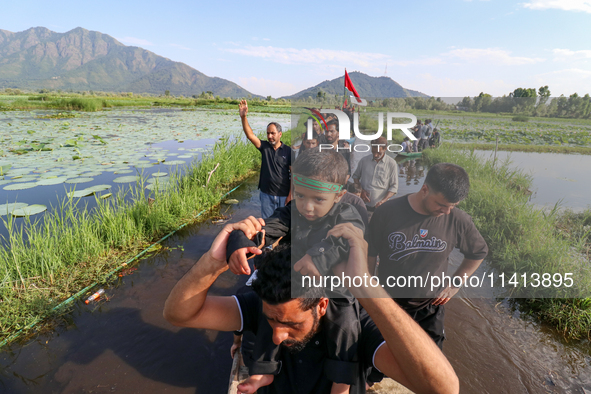 Kashmiri Shia Muslims are mourning as they are taking part in the Ashura procession in boats in the interiors of Dal Lake in Srinagar, India...