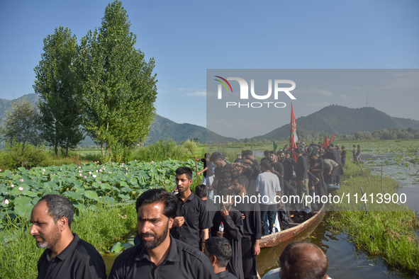 Kashmiri Shia Muslims are mourning as they are taking part in the Ashura procession in boats in the interiors of Dal Lake in Srinagar, India...