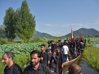 Kashmiri Shia Muslims are mourning as they are taking part in the Ashura procession in boats in the interiors of Dal Lake in Srinagar, India...