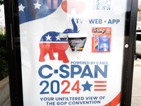 A C-SPAN advertisement at a bus stop is seen covered by political stickers near Red Arrow Park in Milwaukee, Wisconsin on July 16, 2024. (