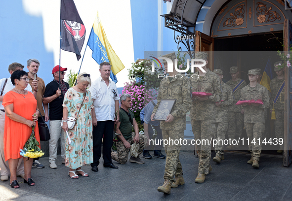 Servicemen are leaving St. Michael's Golden-Domed Cathedral after the memorial service of the commander of the OUN volunteer battalion, Myko...