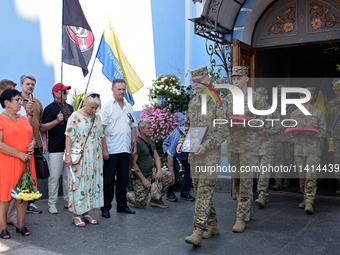 Servicemen are leaving St. Michael's Golden-Domed Cathedral after the memorial service of the commander of the OUN volunteer battalion, Myko...