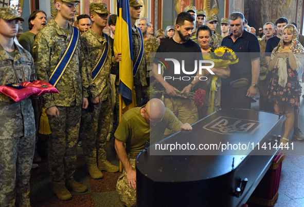 A serviceman is paying his last respects to the commander of the OUN volunteer battalion, Mykola Kokhanivskyi, who died near Vovchansk in th...