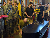 A serviceman is paying his last respects to the commander of the OUN volunteer battalion, Mykola Kokhanivskyi, who died near Vovchansk in th...