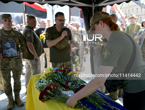 A servicewoman is laying flowers on the coffin of the commander of the OUN volunteer battalion Mykola Kokhanivskyi, who died near Vovchansk...