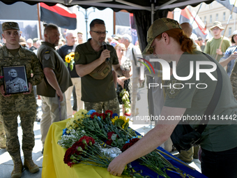 A servicewoman is laying flowers on the coffin of the commander of the OUN volunteer battalion Mykola Kokhanivskyi, who died near Vovchansk...