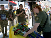 A servicewoman is laying flowers on the coffin of the commander of the OUN volunteer battalion Mykola Kokhanivskyi, who died near Vovchansk...