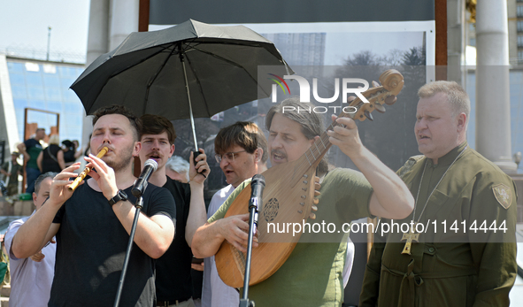 Taras Kompanichenko, the lead vocalist of the Khoreia Kozatska band and junior sergeant, is playing the bandura during a memorial event for...