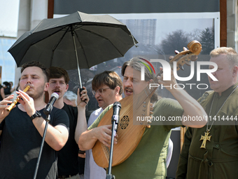 Taras Kompanichenko, the lead vocalist of the Khoreia Kozatska band and junior sergeant, is playing the bandura during a memorial event for...