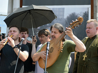 Taras Kompanichenko, the lead vocalist of the Khoreia Kozatska band and junior sergeant, is playing the bandura during a memorial event for...