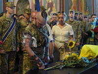 A serviceman is paying his last respects to the commander of the OUN volunteer battalion, Mykola Kokhanivskyi, who died near Vovchansk in th...