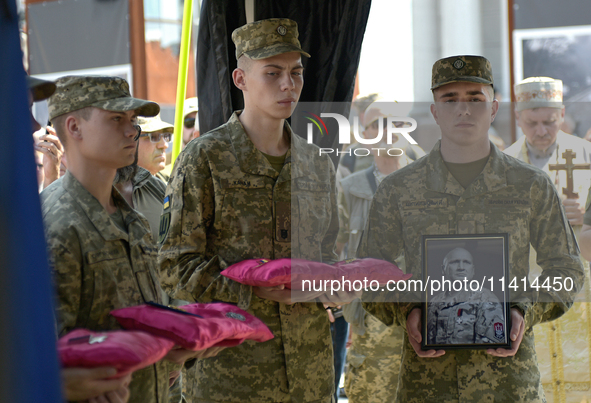 Servicemen are holding the portrait and decorations of the commander of the OUN volunteer battalion Mykola Kokhanivskyi, who died near Vovch...