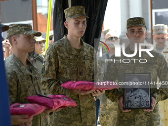 Servicemen are holding the portrait and decorations of the commander of the OUN volunteer battalion Mykola Kokhanivskyi, who died near Vovch...