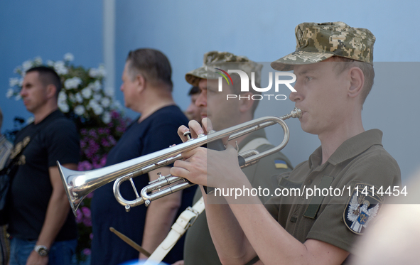 A trumpeter is performing as the procession is leaving St. Michael's Golden-Domed Cathedral after the memorial service of the commander of t...