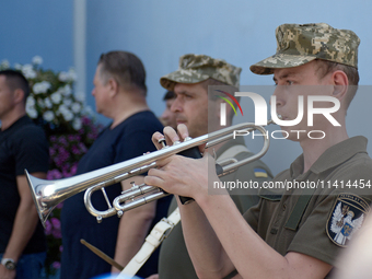 A trumpeter is performing as the procession is leaving St. Michael's Golden-Domed Cathedral after the memorial service of the commander of t...