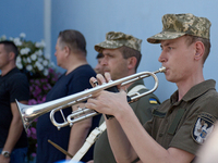 A trumpeter is performing as the procession is leaving St. Michael's Golden-Domed Cathedral after the memorial service of the commander of t...