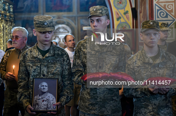 Servicemen are holding the portrait and decorations of the commander of the OUN volunteer battalion Mykola Kokhanivskyi, who died near Vovch...