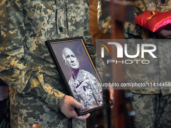 Servicemen are holding the portrait and decorations of the commander of the OUN volunteer battalion Mykola Kokhanivskyi, who died near Vovch...