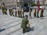 A kneeling man is meeting the procession with the coffin of the commander of the OUN volunteer battalion Mykola Kokhanivskyi, who died near...