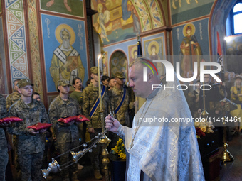 A priest is swinging a censer during a memorial service for the commander of the OUN volunteer battalion Mykola Kokhanivskyi, who died near...