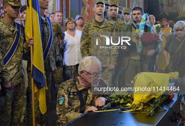 A serviceman is paying his last respects to the commander of the OUN volunteer battalion, Mykola Kokhanivskyi, who died near Vovchansk in th...