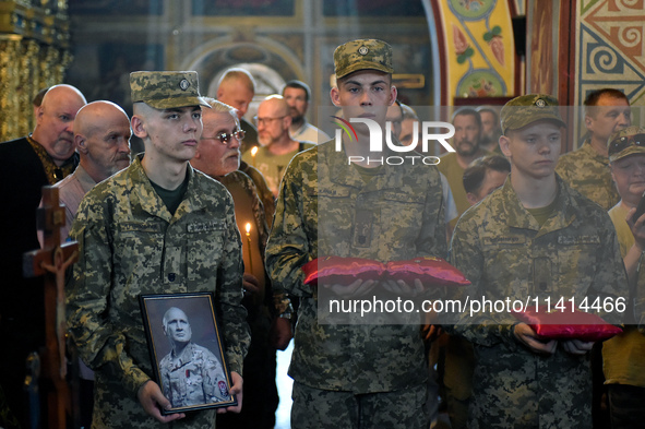 Servicemen are holding the portrait and decorations of the commander of the OUN volunteer battalion Mykola Kokhanivskyi, who died near Vovch...