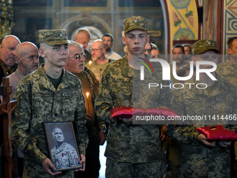 Servicemen are holding the portrait and decorations of the commander of the OUN volunteer battalion Mykola Kokhanivskyi, who died near Vovch...