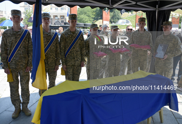 Servicemen are holding the portrait and decorations of the commander of the OUN volunteer battalion Mykola Kokhanivskyi, who died near Vovch...