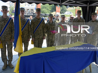 Servicemen are holding the portrait and decorations of the commander of the OUN volunteer battalion Mykola Kokhanivskyi, who died near Vovch...