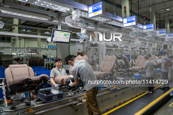 Workers are producing seats ordered by NIO on an assembly line at a workshop of a seating company in Hefei, Anhui province, China, on July 1...