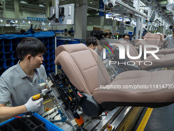 Workers are producing seats ordered by NIO on an assembly line at a workshop of a seating company in Hefei, Anhui province, China, on July 1...