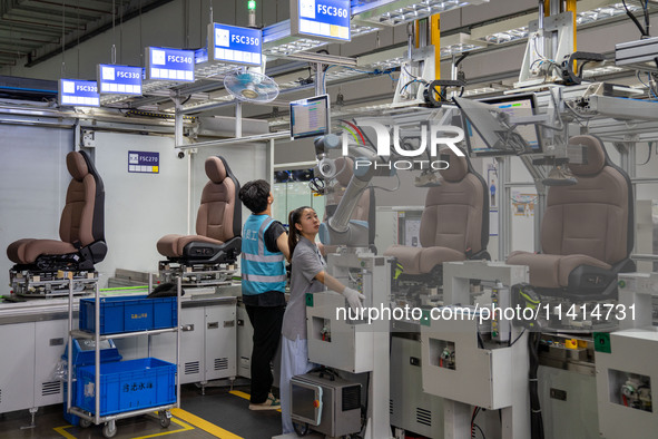 Workers are producing seats ordered by NIO on an assembly line at a workshop of a seating company in Hefei, Anhui province, China, on July 1...