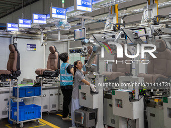 Workers are producing seats ordered by NIO on an assembly line at a workshop of a seating company in Hefei, Anhui province, China, on July 1...