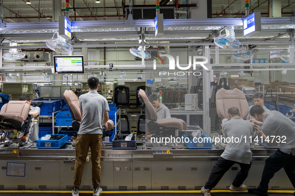 Workers are producing seats ordered by NIO on an assembly line at a workshop of a seating company in Hefei, Anhui province, China, on July 1...