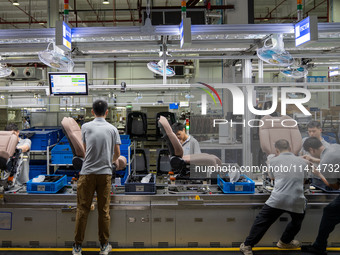 Workers are producing seats ordered by NIO on an assembly line at a workshop of a seating company in Hefei, Anhui province, China, on July 1...