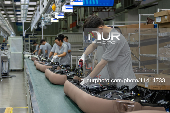 Workers are producing seats ordered by NIO on an assembly line at a workshop of a seating company in Hefei, Anhui province, China, on July 1...