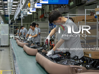 Workers are producing seats ordered by NIO on an assembly line at a workshop of a seating company in Hefei, Anhui province, China, on July 1...