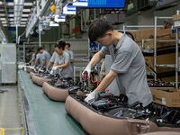 Workers are producing seats ordered by NIO on an assembly line at a workshop of a seating company in Hefei, Anhui province, China, on July 1...