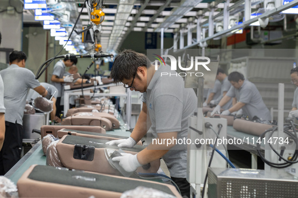 Workers are producing seats ordered by NIO on an assembly line at a workshop of a seating company in Hefei, Anhui province, China, on July 1...