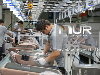 Workers are producing seats ordered by NIO on an assembly line at a workshop of a seating company in Hefei, Anhui province, China, on July 1...