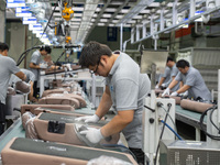 Workers are producing seats ordered by NIO on an assembly line at a workshop of a seating company in Hefei, Anhui province, China, on July 1...